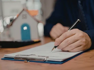 Hombre firmando un contrato que cumple la Ley de Arrendamientos Urbanos